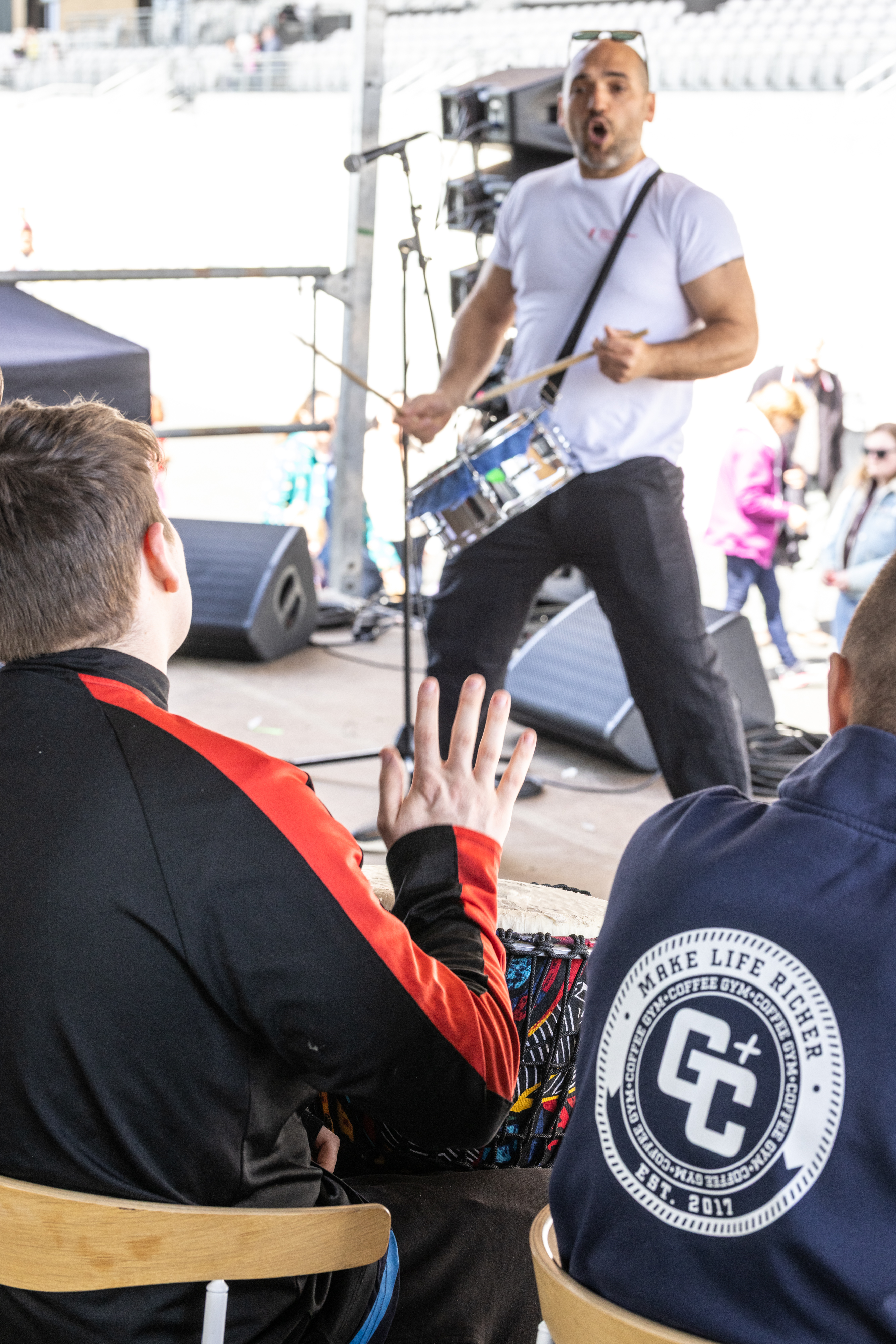 Instructor playing drums on stage. 